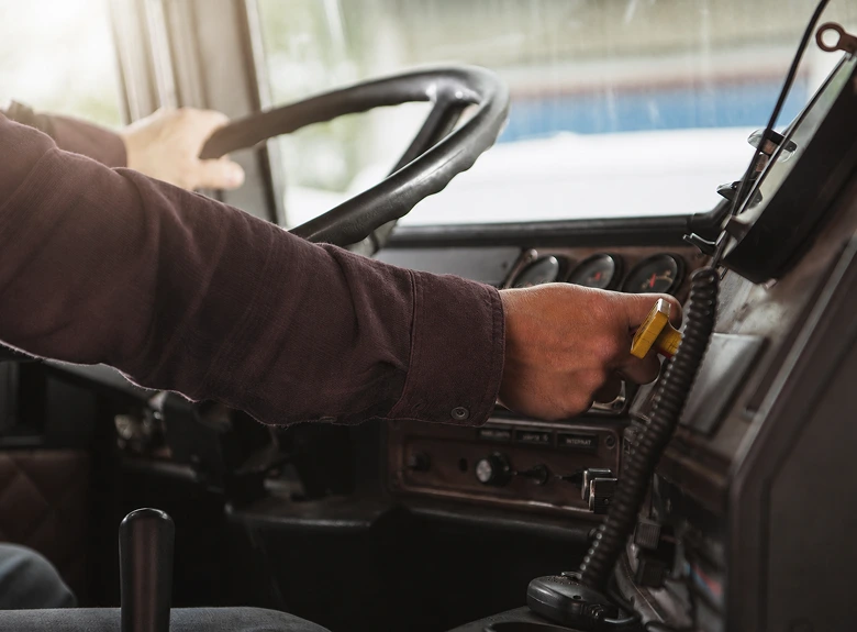 Interior da cabine de um caminhão com motorista ao volante
